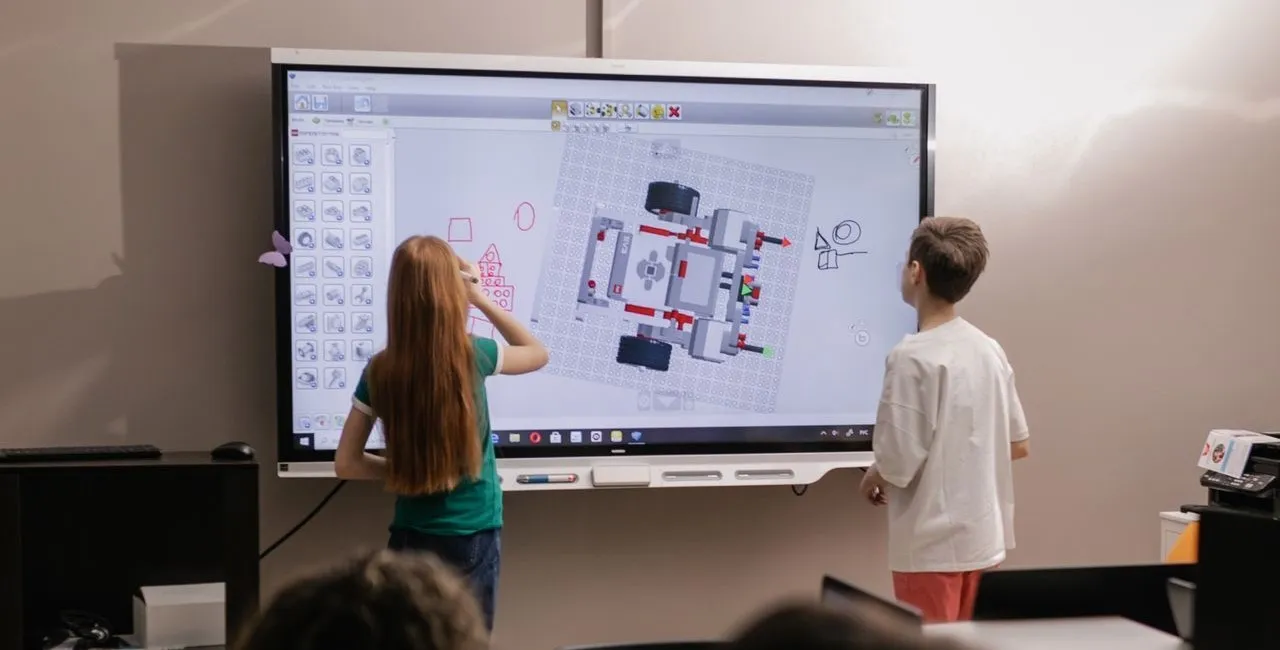Kids learning with an interactive board in a modern classroom setting.